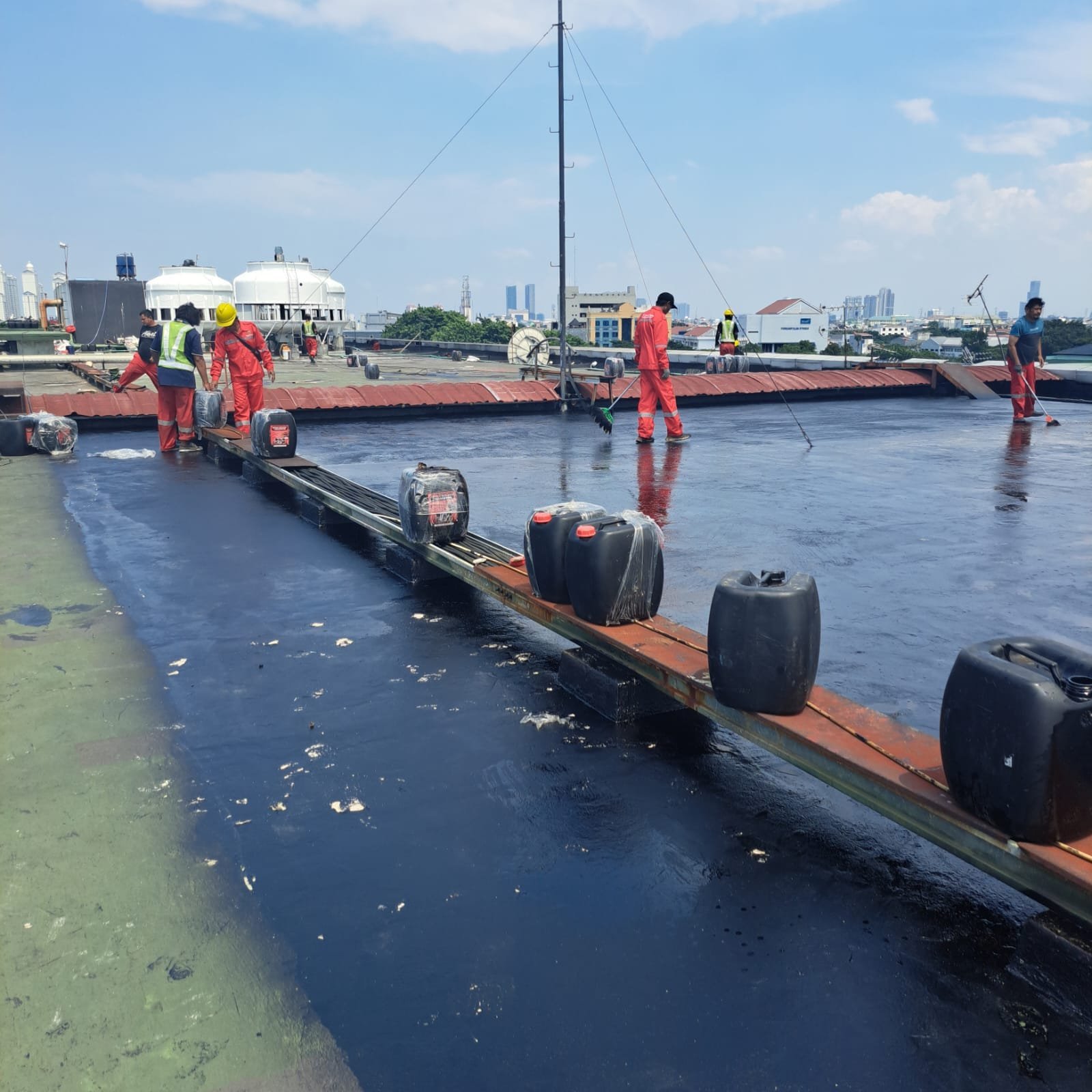 Proses pelapisan aspal cair lapis kedua menyilang